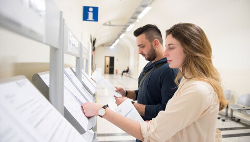 A man and a woman looking at some documents