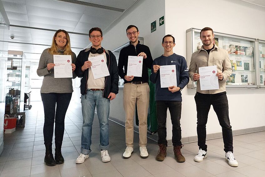 Five poster session winners with their diplomas standing and smiling