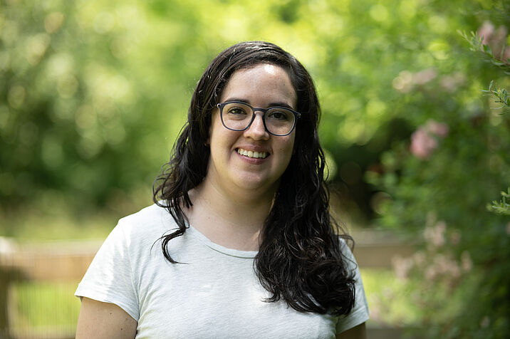 Photo of a dark-haired woman in a white T-shirt