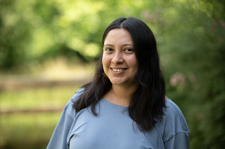 Photo of a dark-haired woman in a blue top