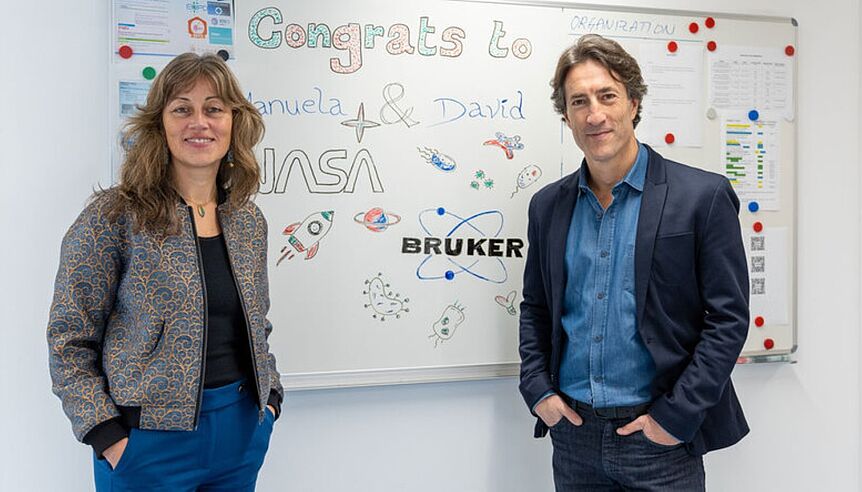 a woman and a man standing in front of a whiteboard