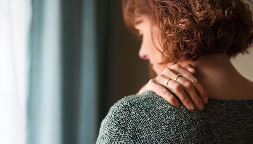 a woman holding her left shoulder