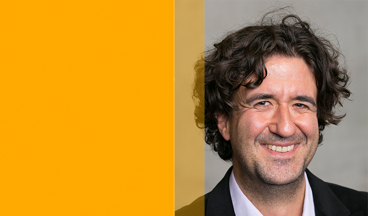 A photo of Prof. Dr. Beyer: a curly-haired smiling man